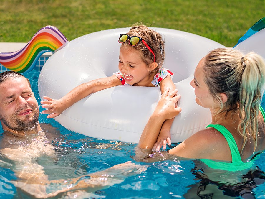 A family playing in a clean backyard pool in Phoenix